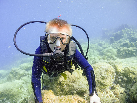 A teenage boy scuba diving on the sea floor