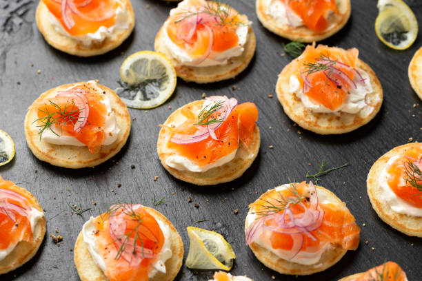 mini tortitas blini con queso tierno, salmón ahumado frío y eneldo - canape buffet cocktail food fotografías e imágenes de stock