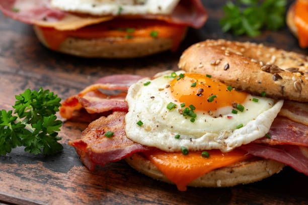 istock Bagel sandwich with bacon, egg and cheese on wooden table. 1776248214