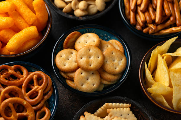 istock Salty snacks crackers, potato chips, pretzel, peanuts, corn puffs. 1776250053