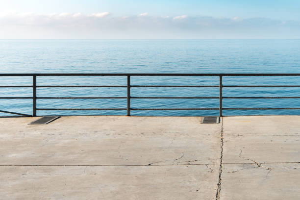 istock Empty concrete ground with metal railings over calm sea 1776253182