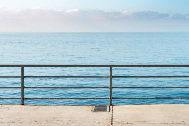 istock Empty concrete ground with metal railings over calm sea 1776253738