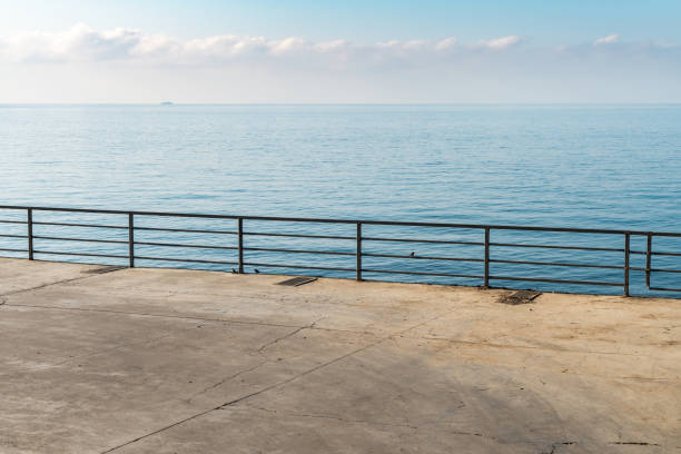istock Empty concrete ground with metal railings over calm sea 1776258703