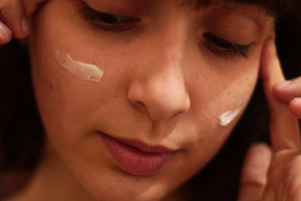 istock Girl Doing Skin Care on her Face with Cream 1776258765