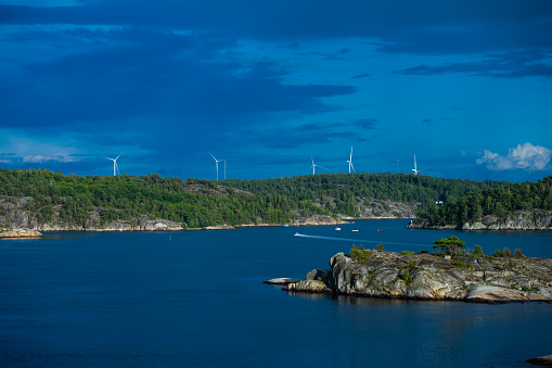 Strömstad, Sweden - July 31 2023: Wind turbines in the distance by the coast.