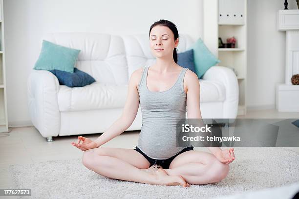 Photo libre de droit de Jeune Femme Enceinte Heureuse Faire Du Yoga À Lintérieur banque d'images et plus d'images libres de droit de Abdomen