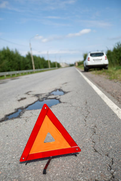 istock Car and red triangle emergency stop sign on asphalt road 1776282831