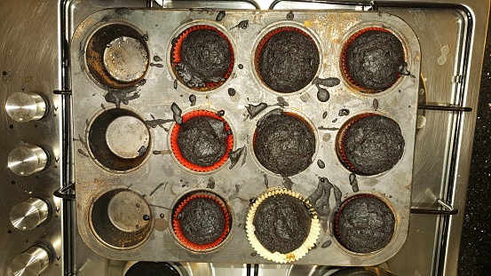 Burnt cakes in boxes taken out of the oven overcooked in a compartment tray placed on an oven.