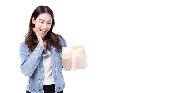 Surprised young woman holding gift box and get excited by open mouth Standing over isolated on white background Beautiful girl happy smile hold new year gift box present Celebrate New Year Christmas