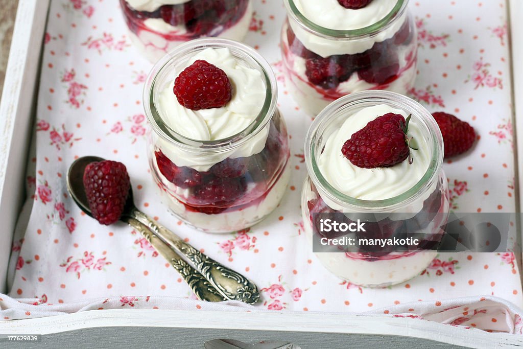 Cream and raspberry dessert Cream and raspberry dessert in small glasses Cream Cheese Stock Photo