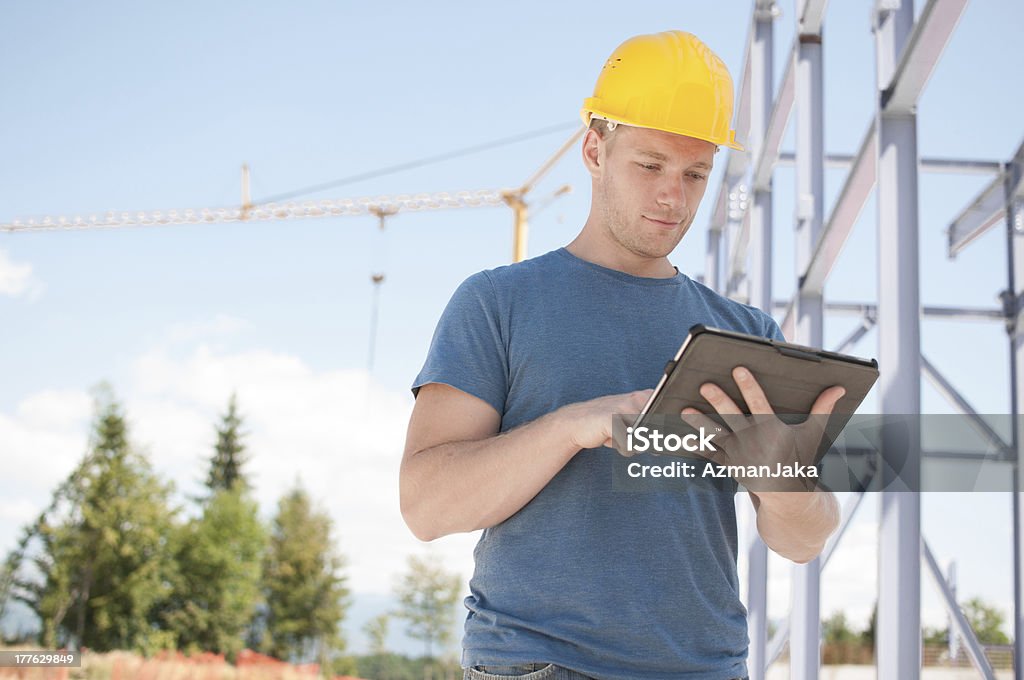 Ingeniero revisando planes en tableta digital - Foto de stock de Accesorio de cabeza libre de derechos