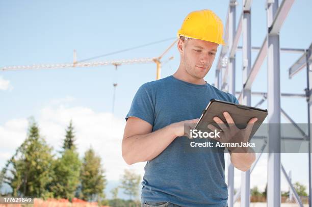 Ingeniero Revisando Planes En Tableta Digital Foto de stock y más banco de imágenes de Accesorio de cabeza - Accesorio de cabeza, Adulto, Agarrar