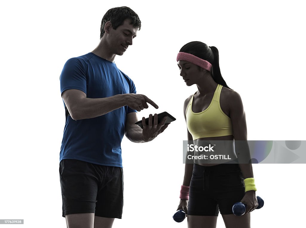 Entrenador Hombre Mujer ejercicio fitness Silueta usando tableta digital - Foto de stock de Adulto libre de derechos