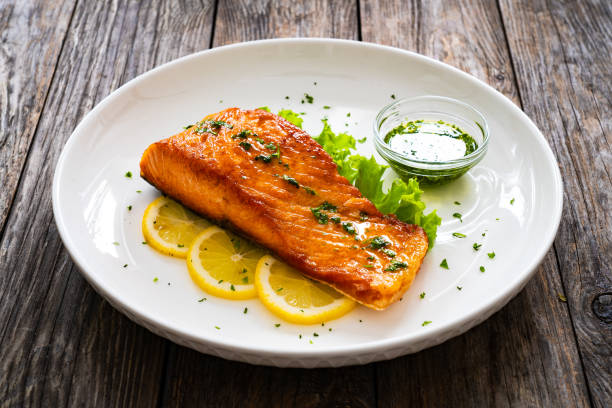 istock Seared salmon with fresh vegetables on wooden table 1776344870