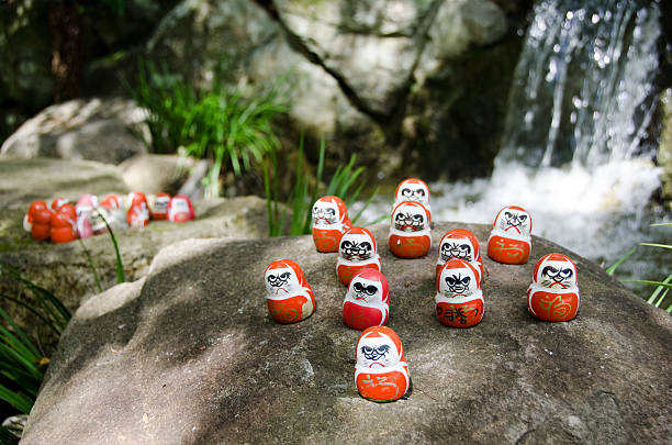 Daruma doll Traditional japanese Daruma dolls in front of a water fall at Katsuo Ji Temple in Mino, Japan dharma stock pictures, royalty-free photos & images