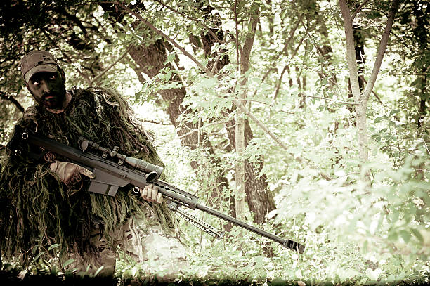 istock Sniper Soldier Hiding in Bush with Ghillie and Precision Rifle 177635893