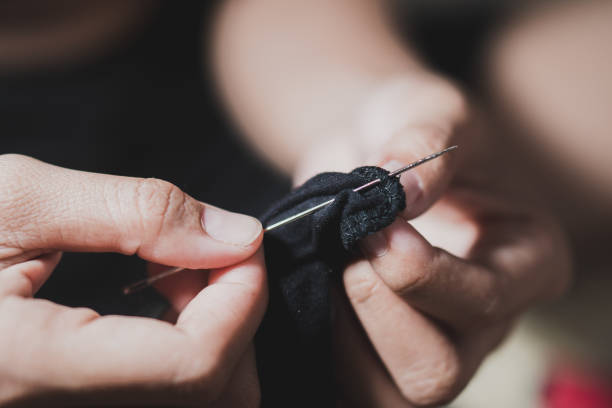 istock Woman fingers threading a needle 1776368102