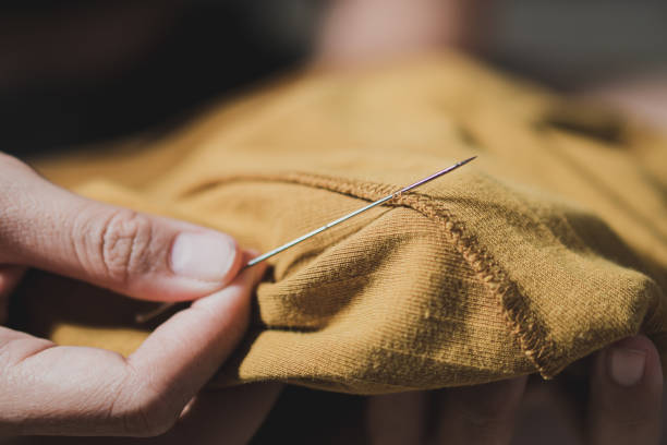 istock Woman fingers threading a needle 1776368618