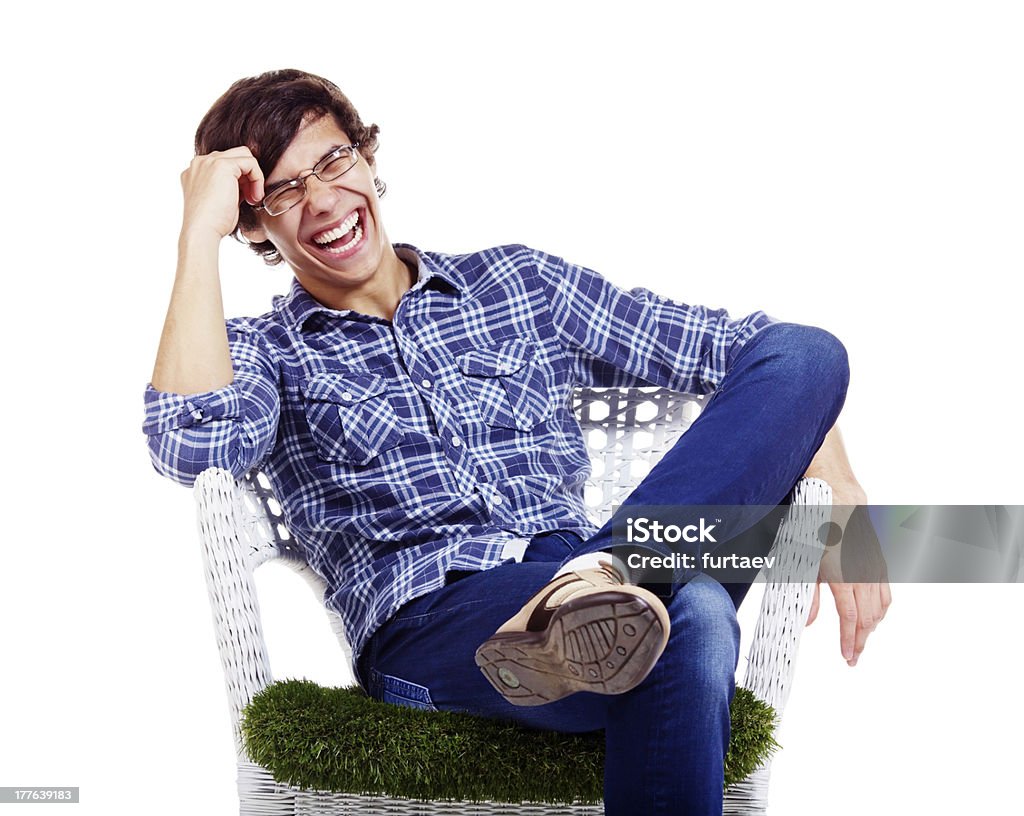 Rilassata uomo ridere in poltrona - Foto stock royalty-free di Abbigliamento casual