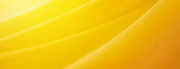 istock yellow silk background. Wave fabric banner copy space 1776392748