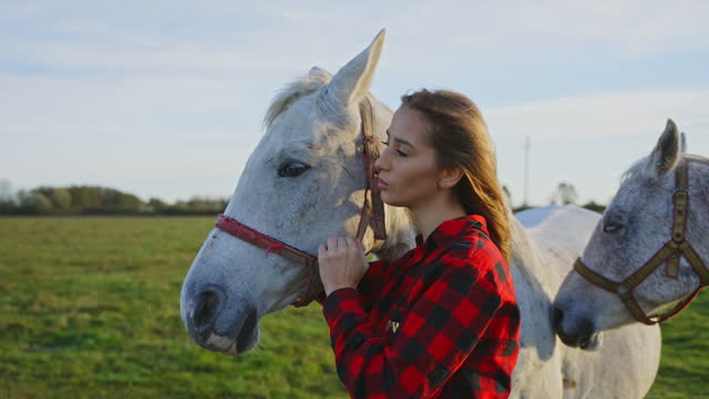 SLO MO Beautiful Young Female Rancher in Red Plaid Shirt Embracing White Horse on Meadow