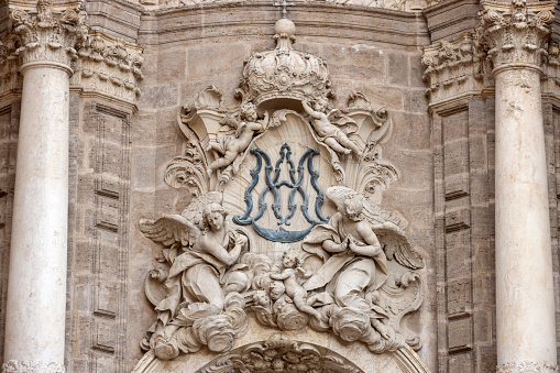 religious decorations above the entrance to Valencia Cathedral (Catedral de Santa María de Valencia), built between 1262 and 1356 and dedicated to the Virgin Mary. The building is an unusual blend of Romanesque, Gothic and Baroque styles; Valencia, Spain