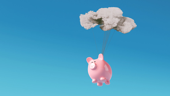 Pink piggy bank is connect with strings to a cloud and flys high in the air.  Concept of saving money online.