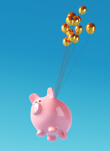 Pink piggy bank is connect with strings to balloons and flys high in the air.  Concept of saving money online.