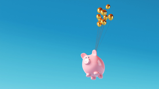 Pink piggy bank is connect with strings to balloons and flys high in the air.  Concept of saving money online.