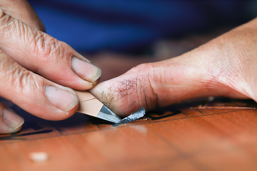 The woodcarving master is carving a plaque. Handmade woodcarving is one of Taiwan's traditional products.