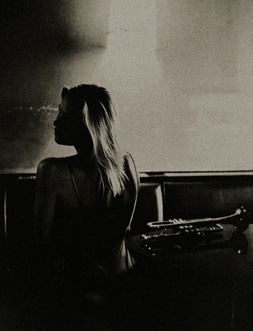 Portrait of a young woman with a trumpet in a night club.