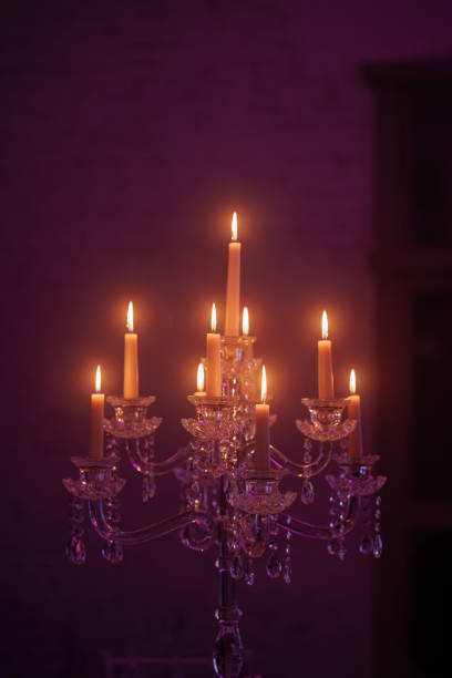 Candelabra with candles in a purple backlit background. Creepy or romantic atmosphere concept.