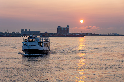 Airport ferry in the harbour near Long Wharf in the Financial District in Boston.  This is taken as the sun rises over Logan Airport.