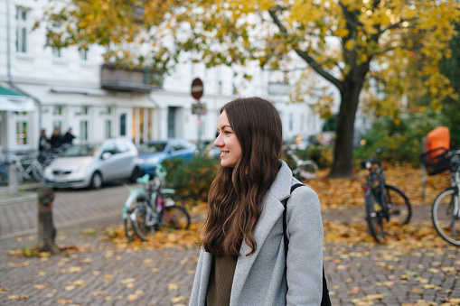 Young smiling woman portrait on the autumn street in Berlin