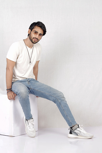 Indoor photo shoot of a pakistani male model in white shirt and blue jeans