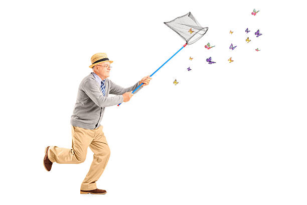 istock Mature man running and catching butterflies with net 177650679