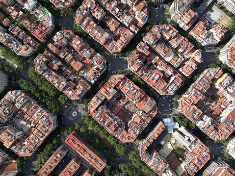 Aerial view of Barcelona Eixample residential district and Sagrada Familia Basilica at sunrise. Catalonia, Spain. Cityscape with typical urban octagon blocks