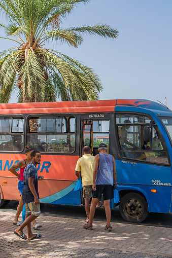 Mindelo, Sao Vicente Island, Cape Verde - October 07.2023: Street scene of Mindelo on Sao Vicente island with a public bus and people