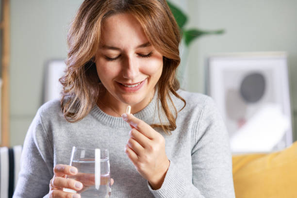 istock Happy young woman taking vitamins 1776521031