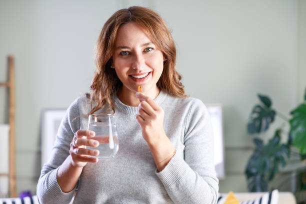 istock Young woman taking Omega 3 capsule 1776521643