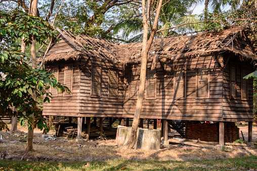 A wooden jungle hut lies derelict, Siem Reap, Cambodia