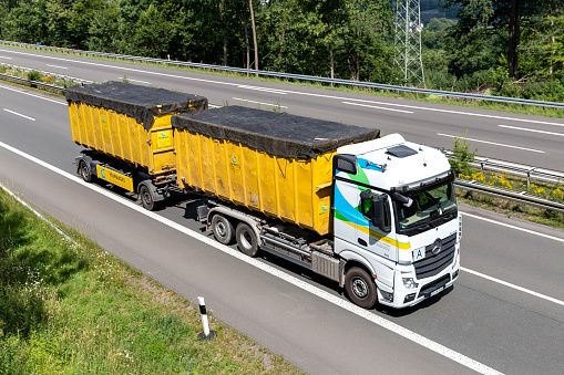 Wiehl, Germany - June 25, 2020: Hufnagel Mercedes-Benz Actros roll-off container truck on motorway