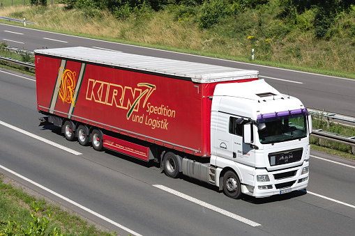 Wiehl, Germany - June 25, 2020: MAN Service MAN TGX truck with Kirn curtainside trailer on motorway