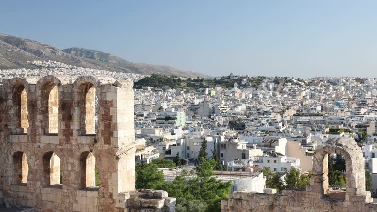 View of modern city of Athens and Arches of Odeon of Herodes Atticus.