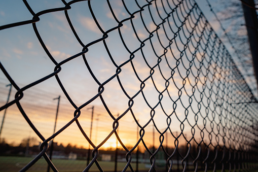wire mesh fence in front of sunset sky