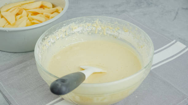 istock Cake dough in a glass bowl close-up on a kitchen table. Apple cake recipe 1776557234