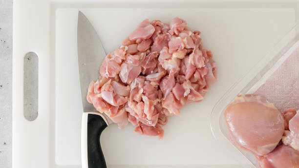 istock Chopped raw chicken fillet close-up on a white plastic cutting board 1776558155