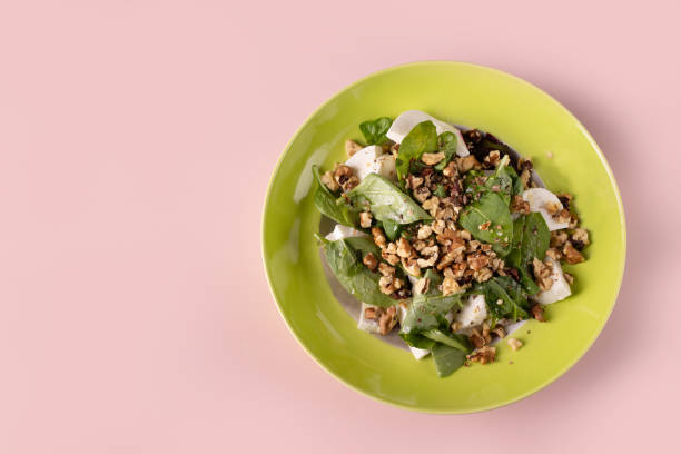 istock salad with mozzarella, spinach, beets, walnuts on a round green plate, top view, copy space 1776559360