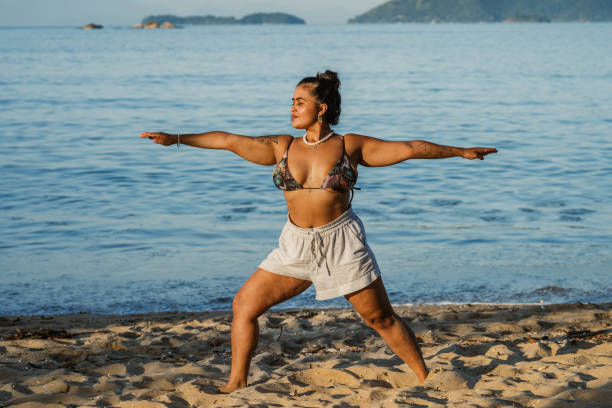 istock Young woman practicing yoga on a sandy beach in summer 1776570946