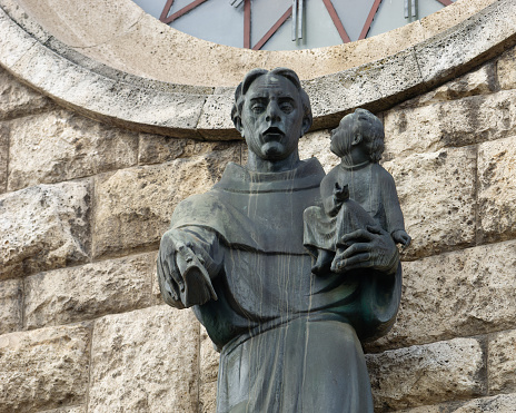 Close-up photo of a statue of Saint Anthony of Padua above the entrance of the church of Saint Anthony of Padua, Sveti Duh, Zagreb, Croatia